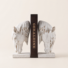 Load image into Gallery viewer, Set of two rustic white horse head bookends by Decor Home holding a brown book.