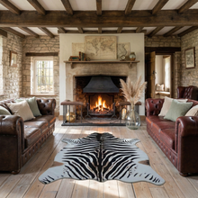 Load image into Gallery viewer, Faux zebra print rug on wood floor in cozy living room with fireplace and leather sofas