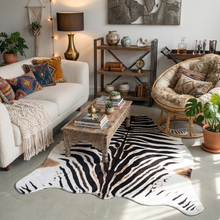 Load image into Gallery viewer, Large faux zebra print rug in a cozy, boho living room with textured décor accents.

