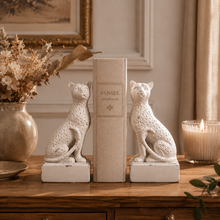Load image into Gallery viewer, Maison Leopard Bookends in rustic white resin holding a book on a wooden table
